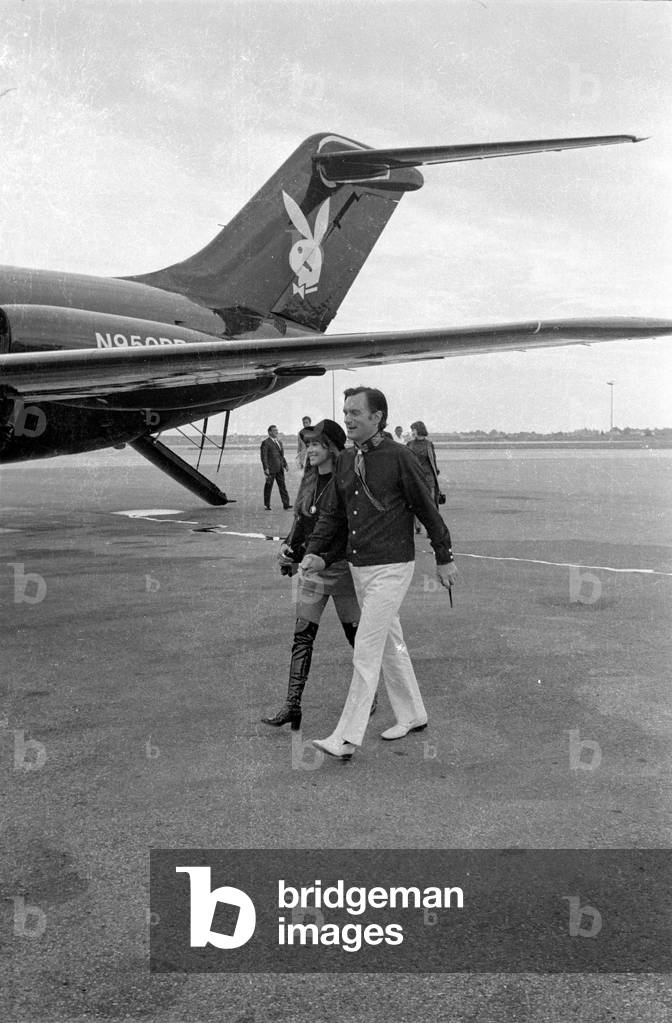 Hugh Hefner and Barbi Benton on the way to his private jet, 1970 (b/w photo)