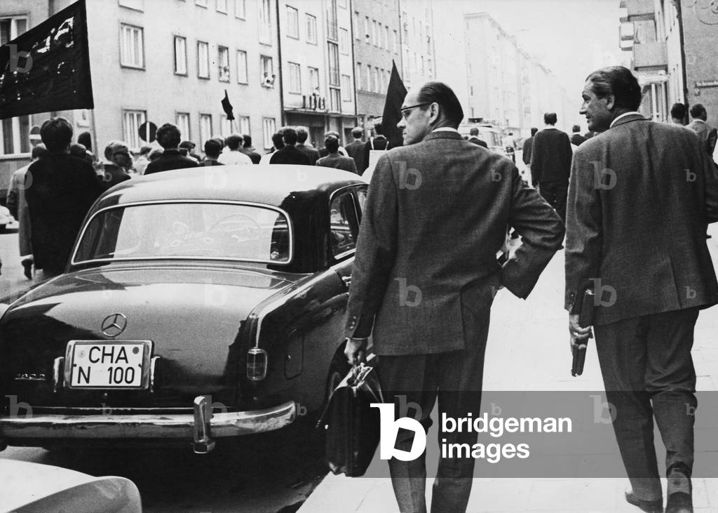 Protest train in a street in Munich after the death of shot dead in Berlin Benno Ohnesorg. Passers-by watch, 1967 (b/w photo)