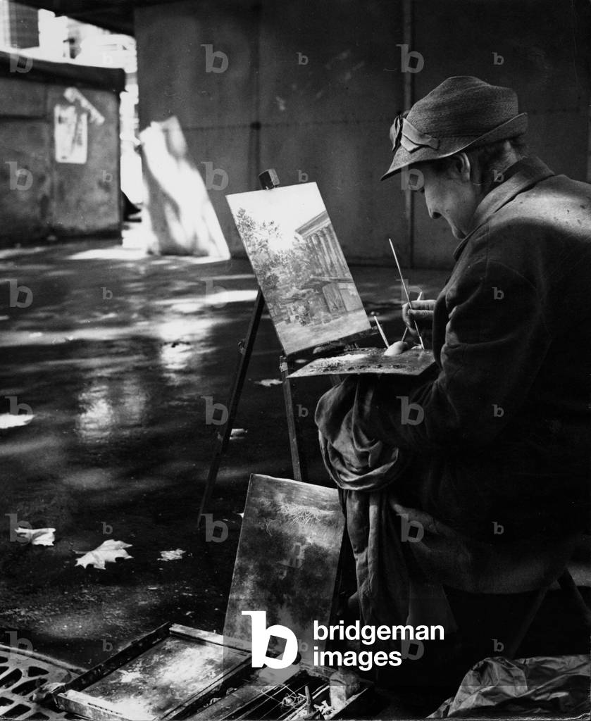 A street artist painting the 'Madeleine', 1959 (b/w photo)