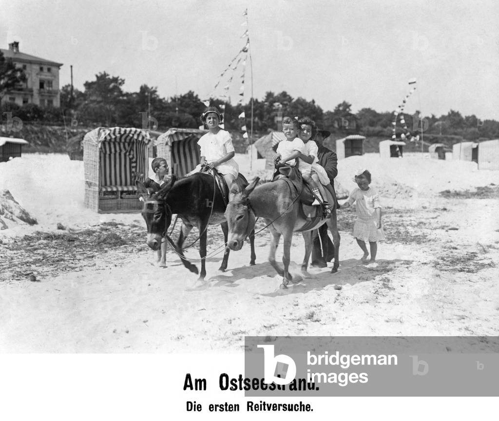 Riding children on the Baltic Sea beach, c.1910 (b/w photo)