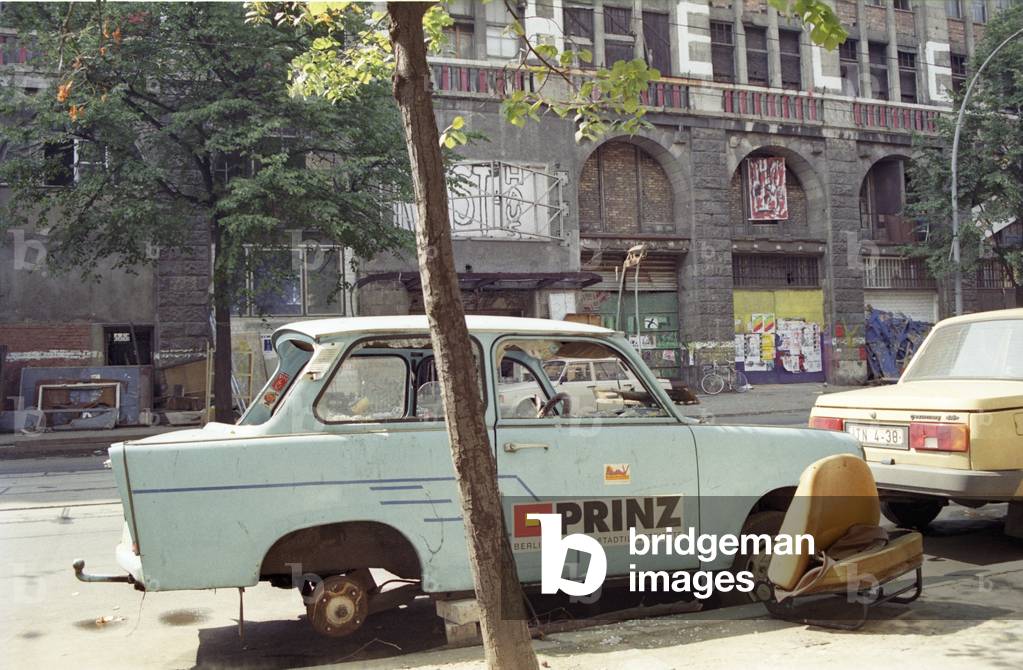 'Tacheles', in Berlin 08/91 thg Das Kunsthaus Tacheles in der Oranienburger Straße in Berlin im August 1991 Deutschland Ostberlin Ost Stadt Hauptstadt DDR Gebäude Architektur Außenansicht Kunst Künstler Künstlerinitiative besetzt besetztes Haus Kunsthaus Ruine Abbruchhaus Denkmal Denkmalschutz denkmalgeschützt geschützt vorne Vorderseite Straßenseite Trabant Trabi Trabbi Prinz Stadtmagazin Stadtillustrierte Werbung Reklame PKW Auto german architecture quer draußen (photo)