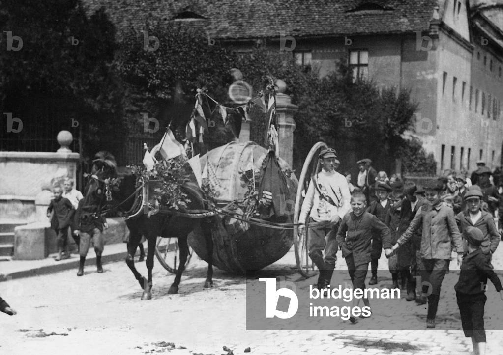 Man rolls an advertisement ball through Germany, 1913 (b/w photo)