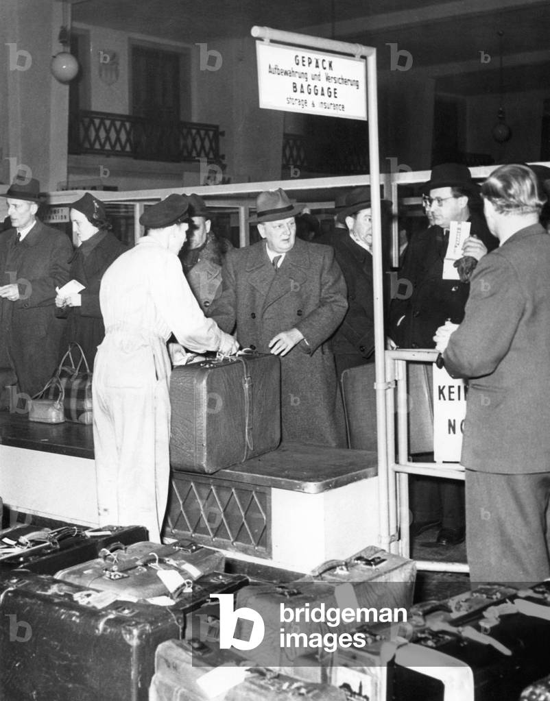 Passengers in the baggage claim area, 1950s (b/w photo)