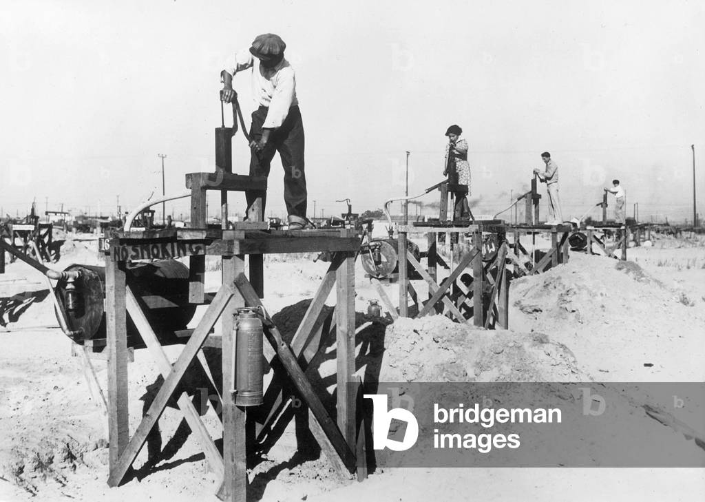 Unemployed in the petroleum production with home-made pumps, 1935 (b/w photo)