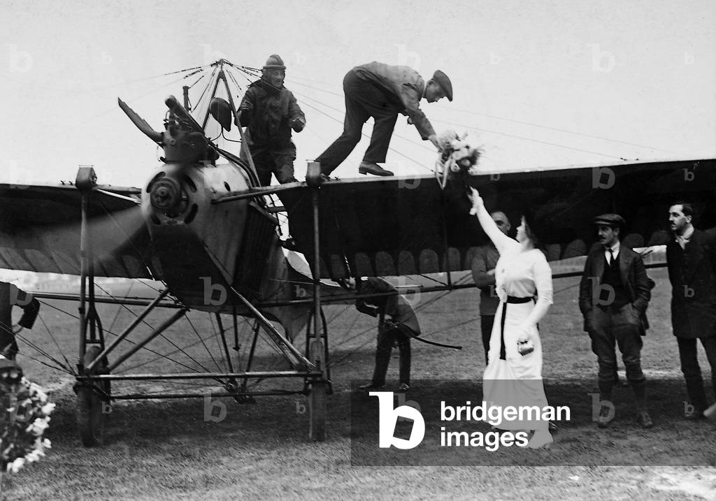 At the Berlin-Johannisthal airfield, the pioneer and owner of the aircraft repair plant in Strausberg Alfred Friedrich is greeted by a woman with flowers after he successfully completed the Berlin-Paris-London-Berlin route. His plane was the so-called Etrich pigeon built by himself. The first long-haul flight Berlin-Paris-London-Berlin over a distance of 2500 kilometres in September 1913, in which the then 22-year-old Alfred Friedrich crossed the canal twice with a passenger on board, represented an enormous achievement in that stage of development of international aviation, 1913 (b/w photo)