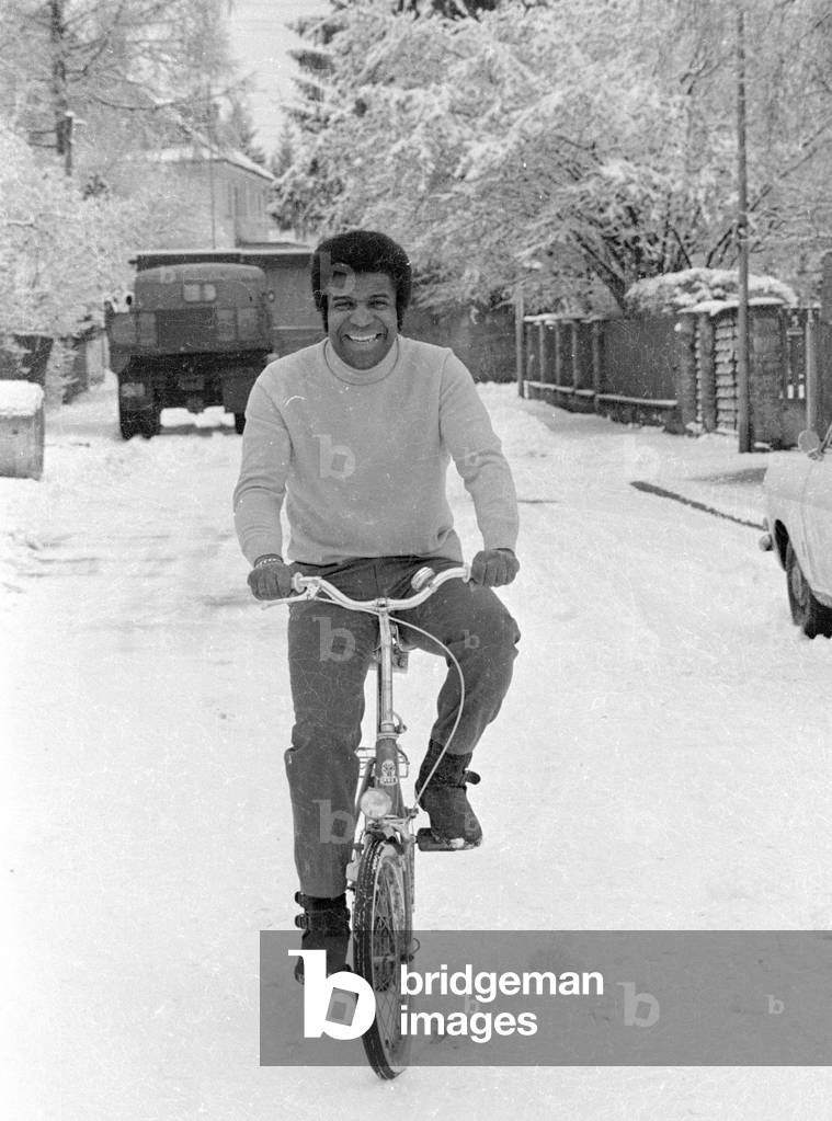 Roberto Blanco with bike in the snow, 1971 (b/w photo)