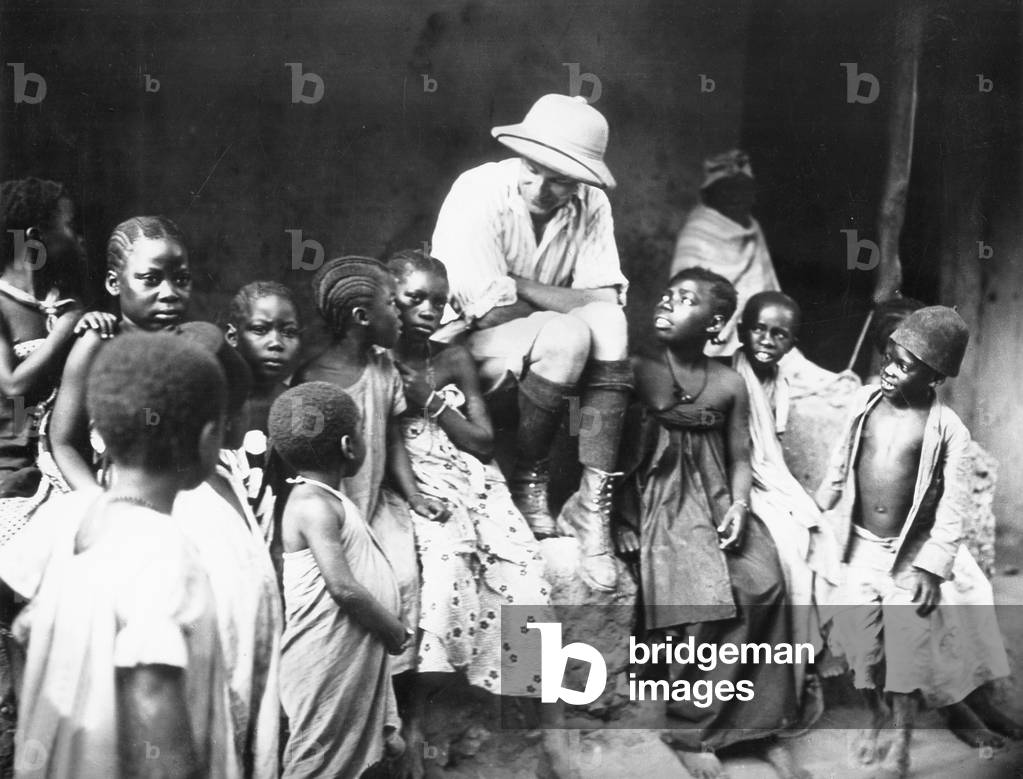 A European in an African village, 1935 (b/w photo)