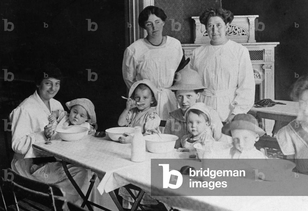 High society ladies serving food to children, 2.11.1914 (b/w photo)