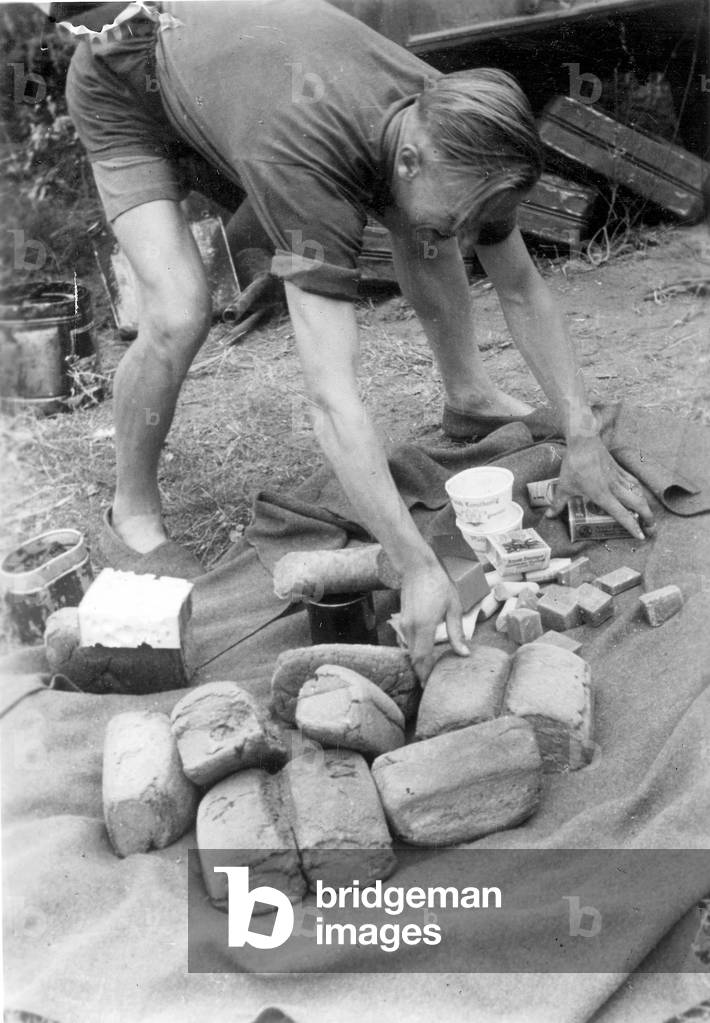 A German soldier sorts food (b/w photo)