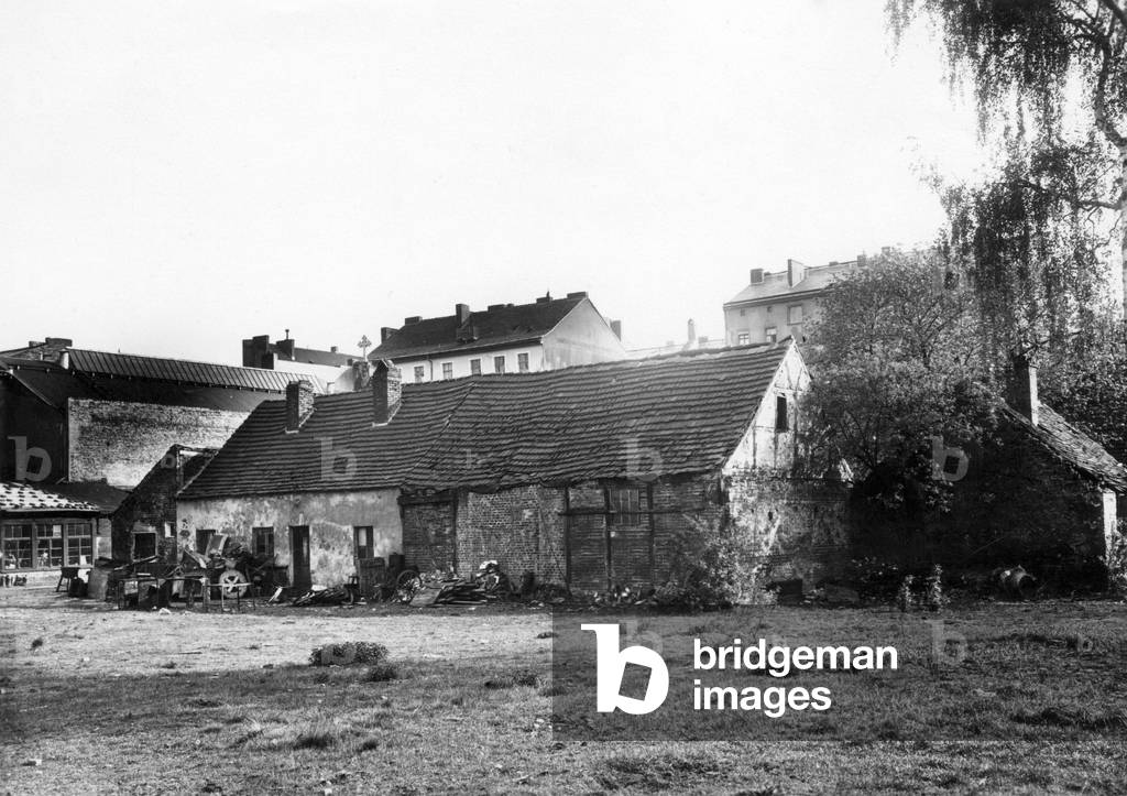 Old farm in front of tenement buildings in Berlin, 1932 (b/w photo)
