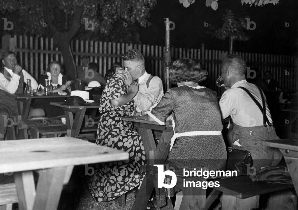 Kissing couple in a wine bar in Vienna, 1936 (b/w photo)