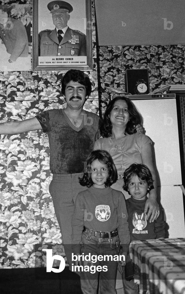 Turkish family Yesiltepe in their apartment with a portrait of the Turkish President Kenan Evren, Munich, 1982 (b/w photo)