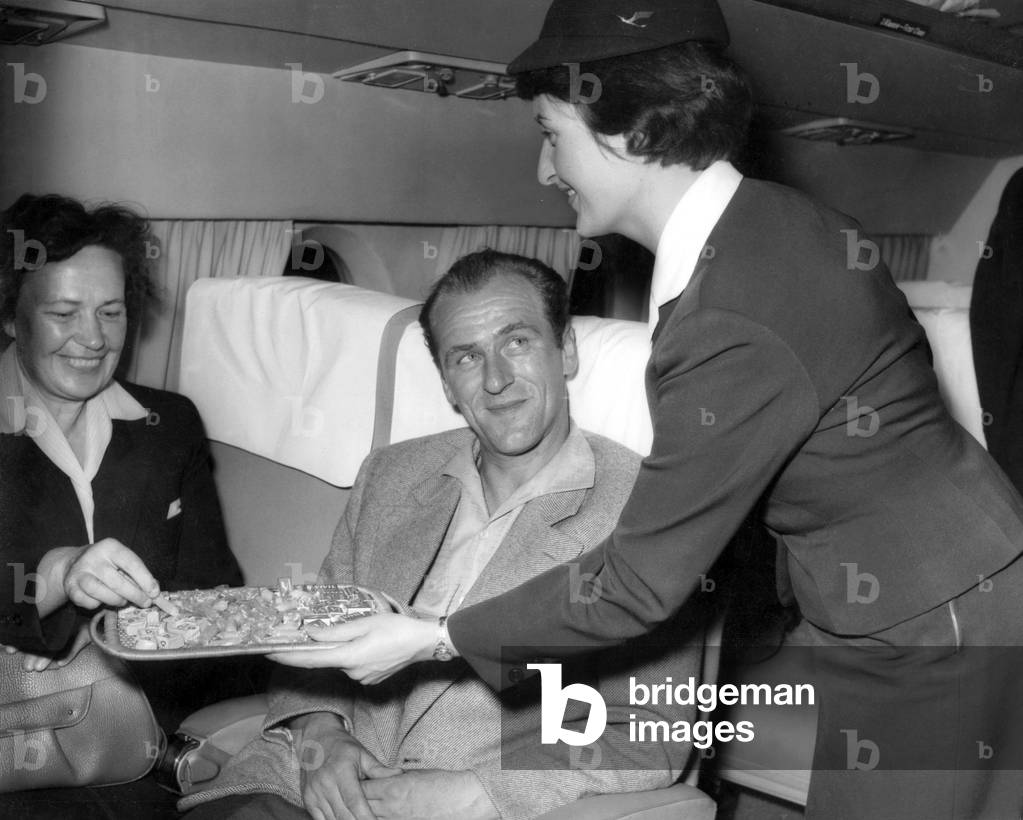 Stewardess serves passengers on a Lufthansa flight (b/w photo)