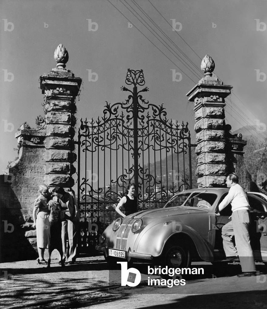 A group of friends take a break from a driving excursion, 1939 (b/w photo)