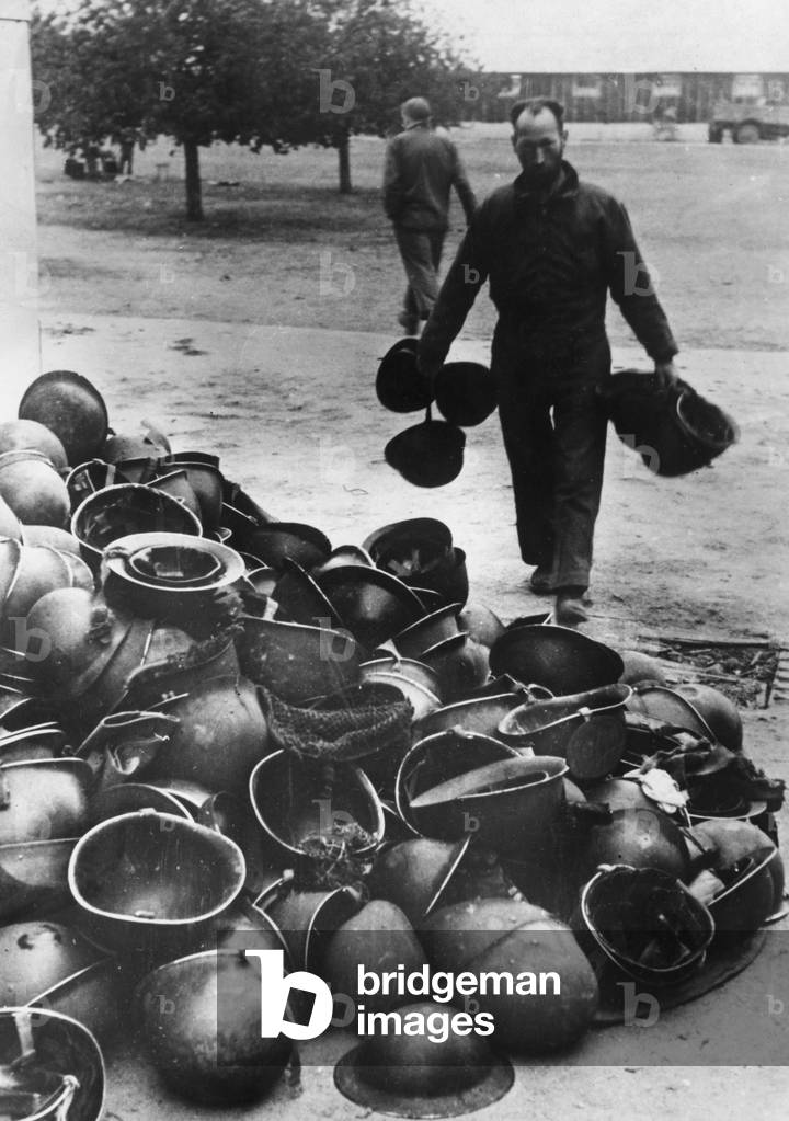 Helmets of Allied soldiers in a POW transit camp, 1944 (b/w photo)