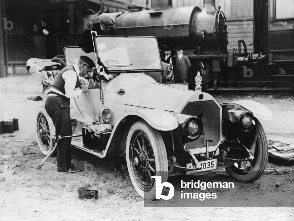 Henry of Prussia repairs his racing car, 1911 (b/w photo)
