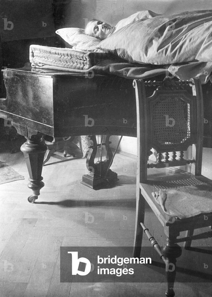 A quartered woman on a makeshift sleeping place after the Second World War (b/w photo)