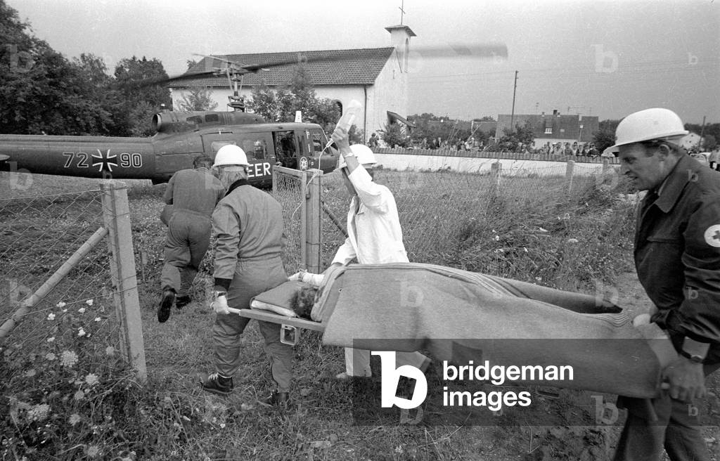 An accident victim is brought to the rescue helicopter, 1970 (b/w photo)