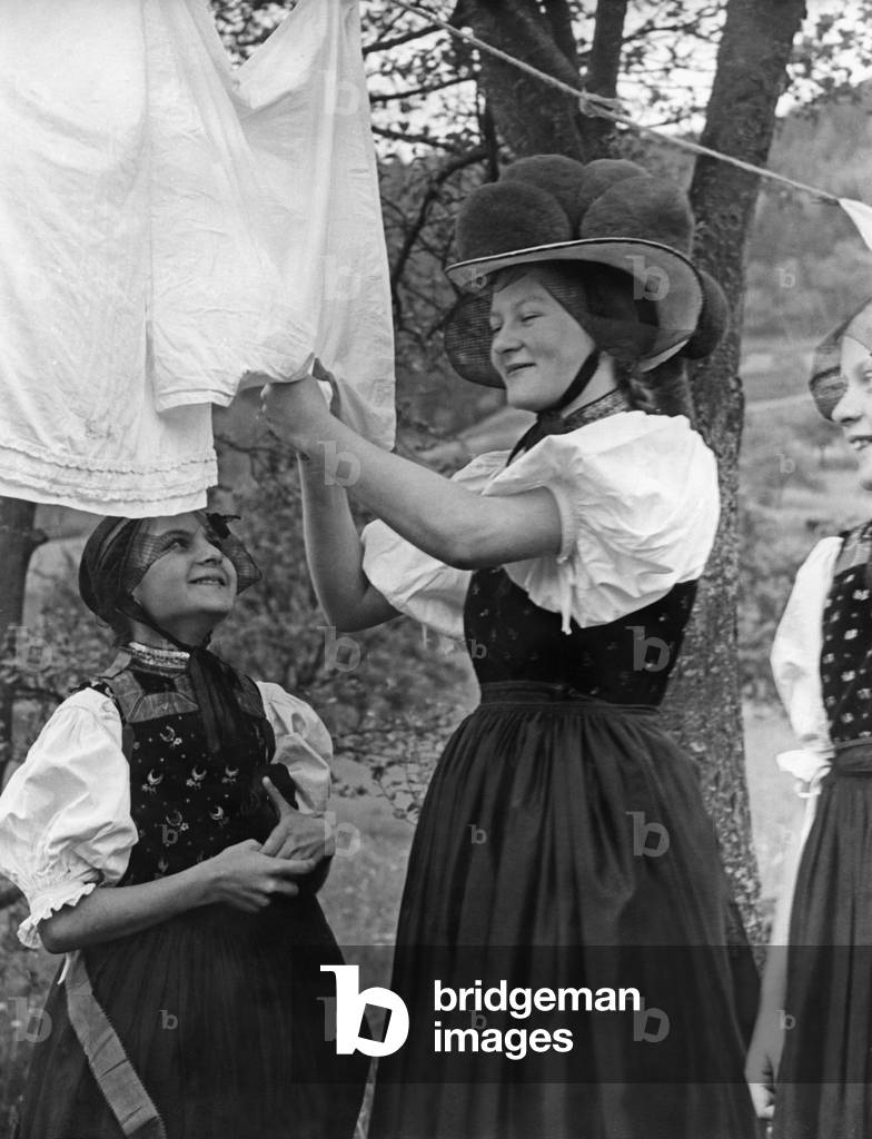 Black Forest girl in traditional costume doing housework, c.1930 (b/w photo)