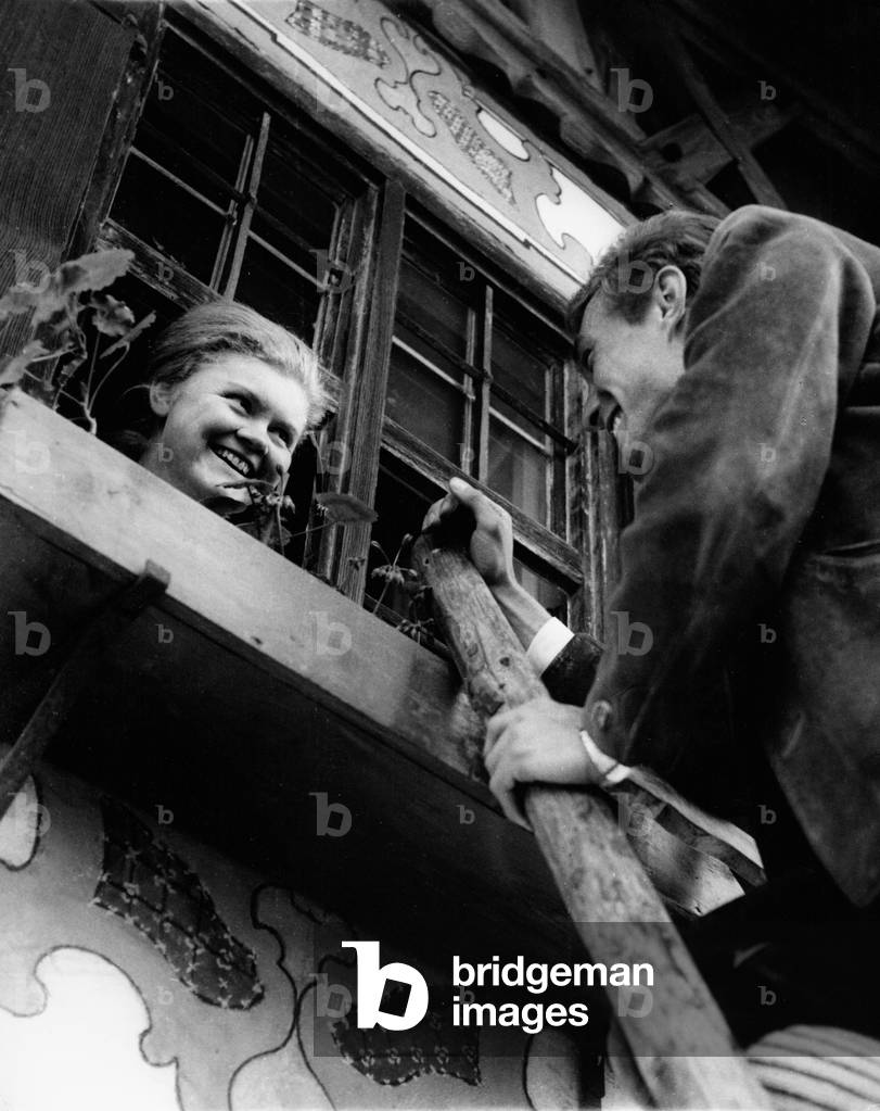 A man climbing a ladder to visit a girl in Bavaria, 1968 (b/w photo)