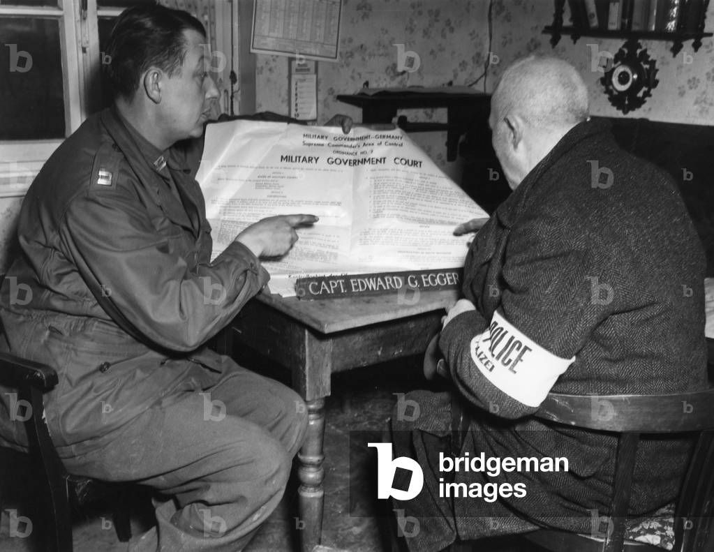 Soldier of the US Army instructing a policeman, 1945 (b/w photo)