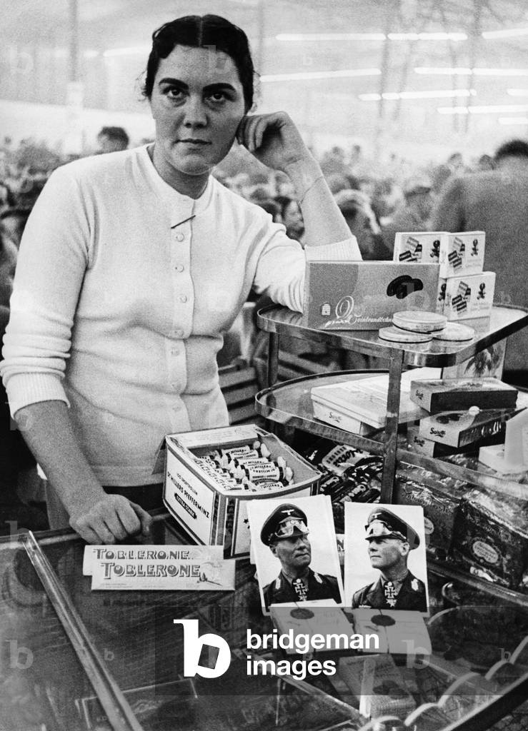 Saleswoman with Erwin Rommel chocolate, 1956 (b/w photo)