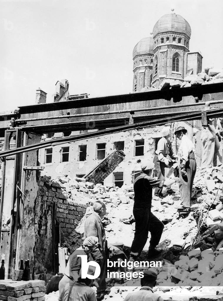 Women and men work on a pile of rubble in Munich, 1945 (b/w photo)