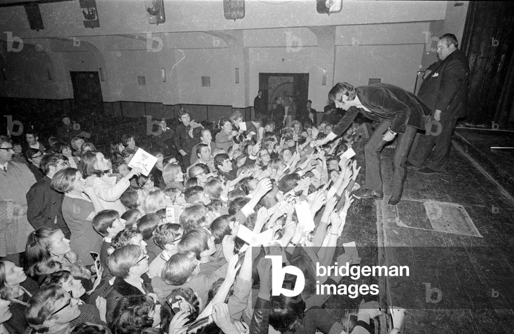 Udo Juergens gives autographs after a concert, 1969 (b/w photo)