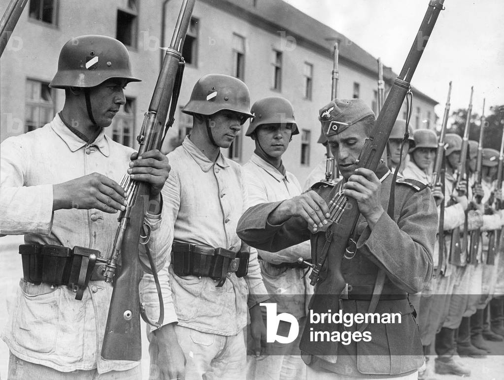 Non-commissioned officer shows recruits how to load a carbine, 1940 (b/w photo)