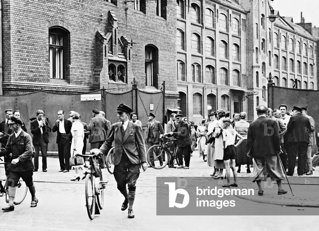Workers leave their factory at the end of the work, 1935 (b/w photo)