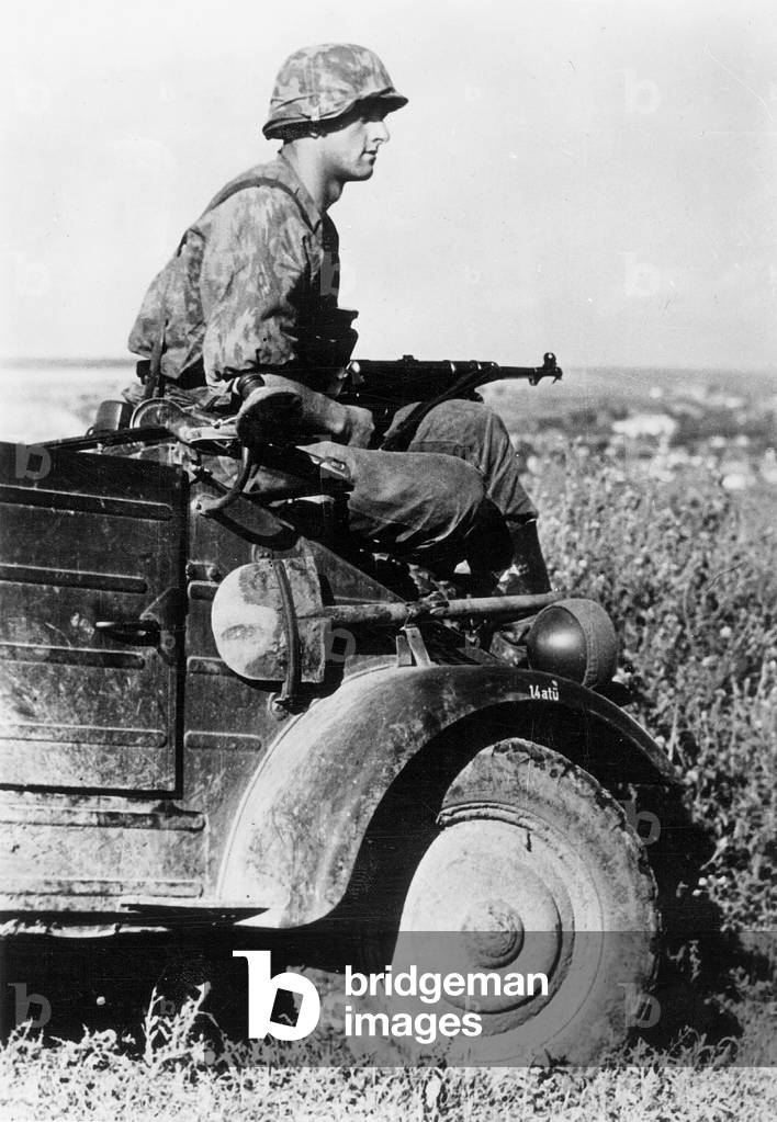 A soldier of the Waffen-SS on a military utility vehicle, 1941 (b/w photo)