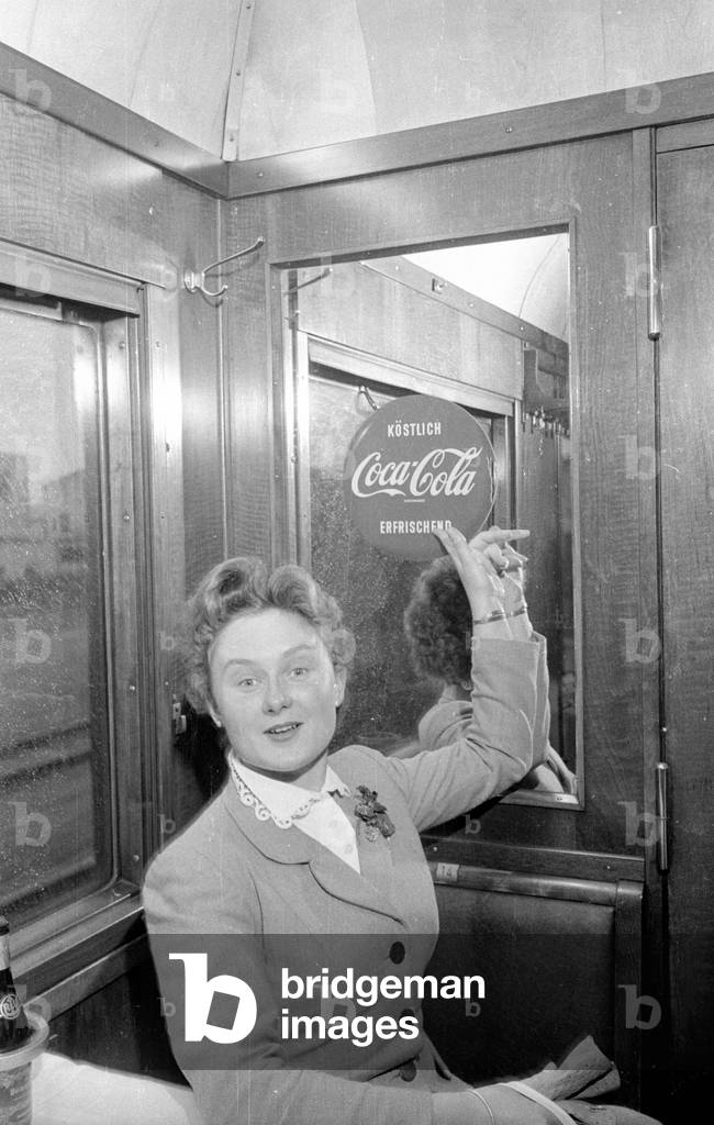 Traveler points to a billboard of Coca Cola, 1954 (b/w photo)