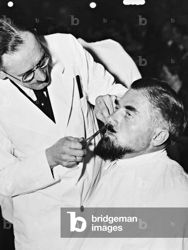 Hairdresser while shaving, 1935 (b/w photo)