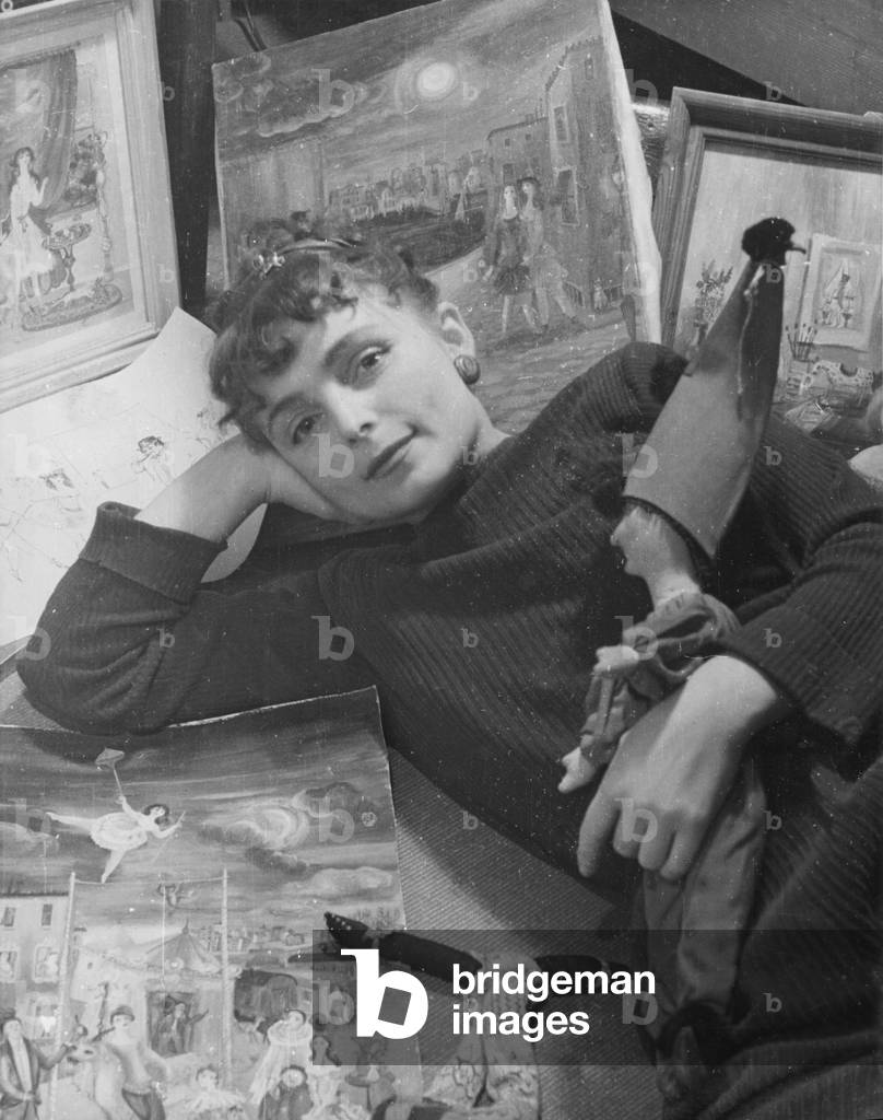 Painter with her paintings (b/w photo)