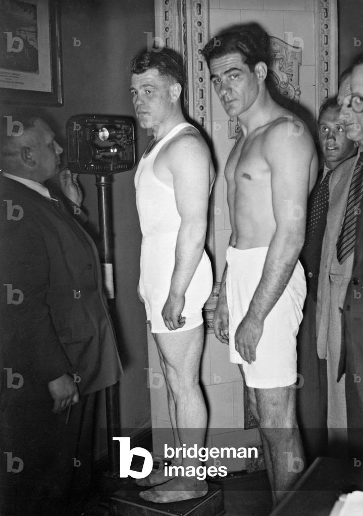 Adolf Heuser and Norman Tomasulo weighing in, 1936 (b/w photo)