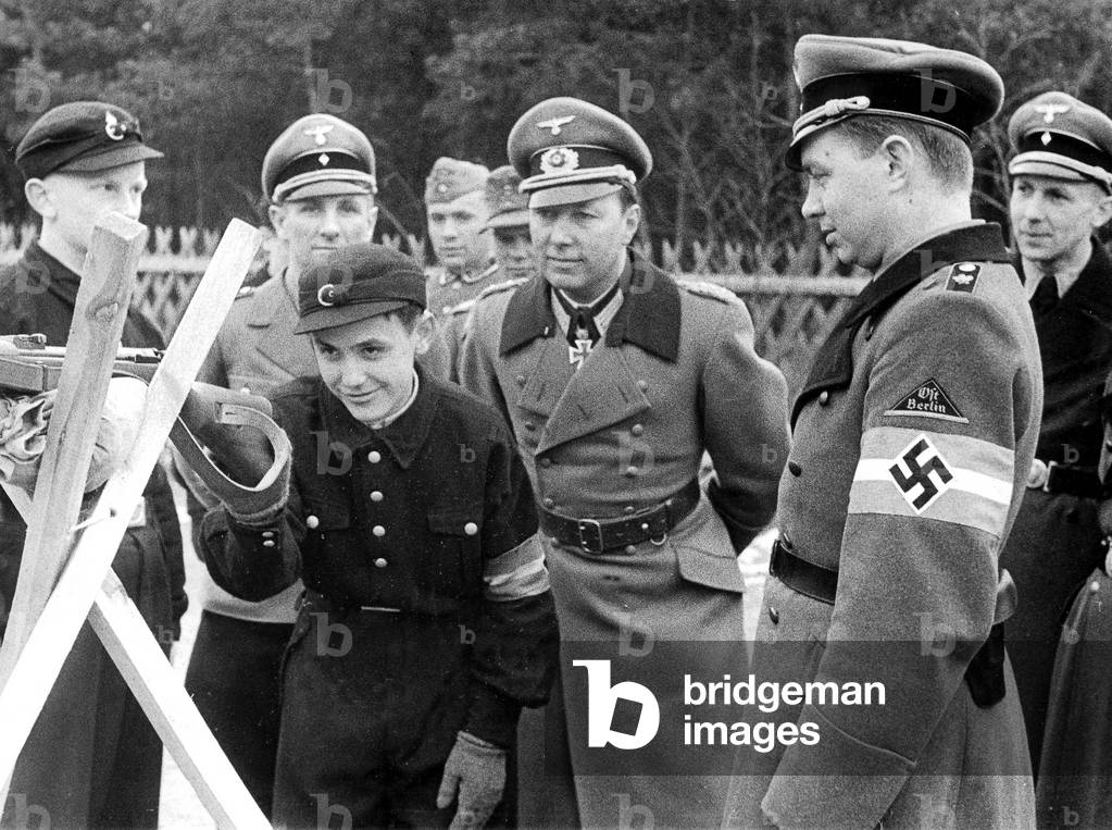 Niemack and Hamann watch Hitler Youth boy at his drill to aim, 1944 (b/w photo)