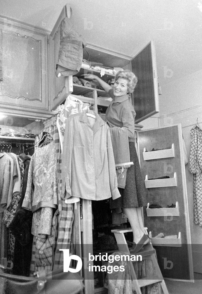 Heidi Bruehl in front of her wardrobe, 1959 (b/w photo)