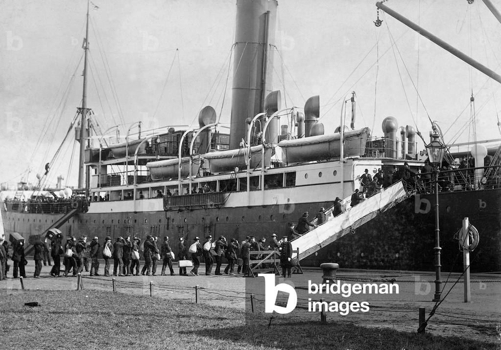 German emigrants go with their luggage aboard an emigrant ship in the port of Hamburg, 1902 (b/w photo)