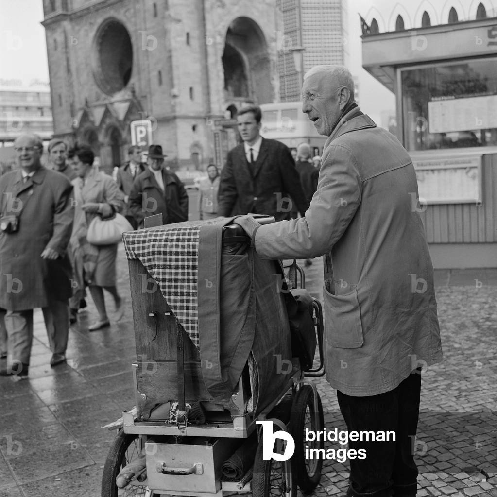 Old Man with a hurd-gurdy near Kaiser Wilhelm Memorial Curch in Berlin, 1964 (b/w photo)
