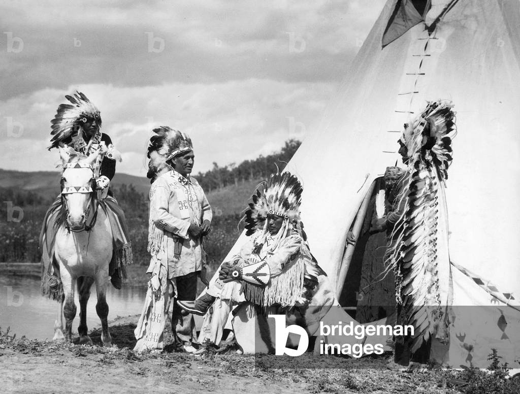 Indians in front of a tent. (b/w photo)