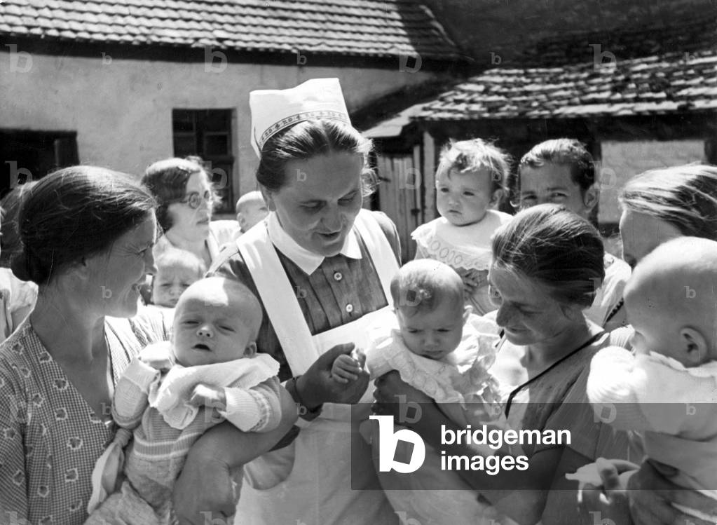 Nurse with mothers and babies, 1938 (b/w photo)