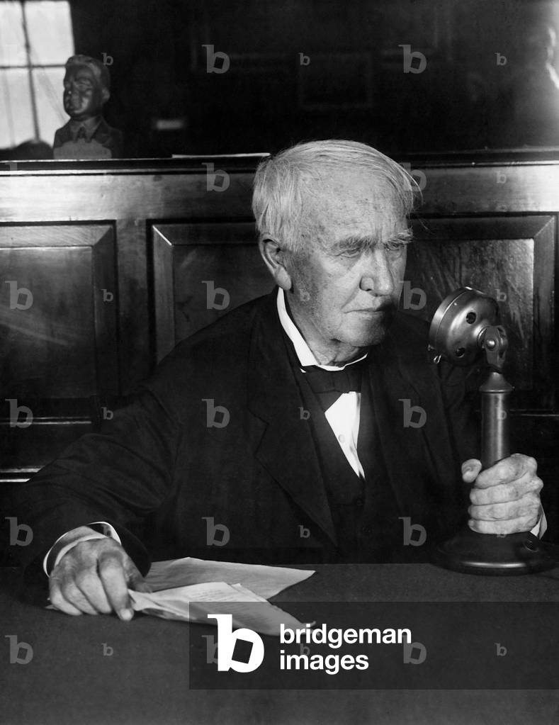 Thomas Alva Edison with a microphone, 1930 (b/w photo)