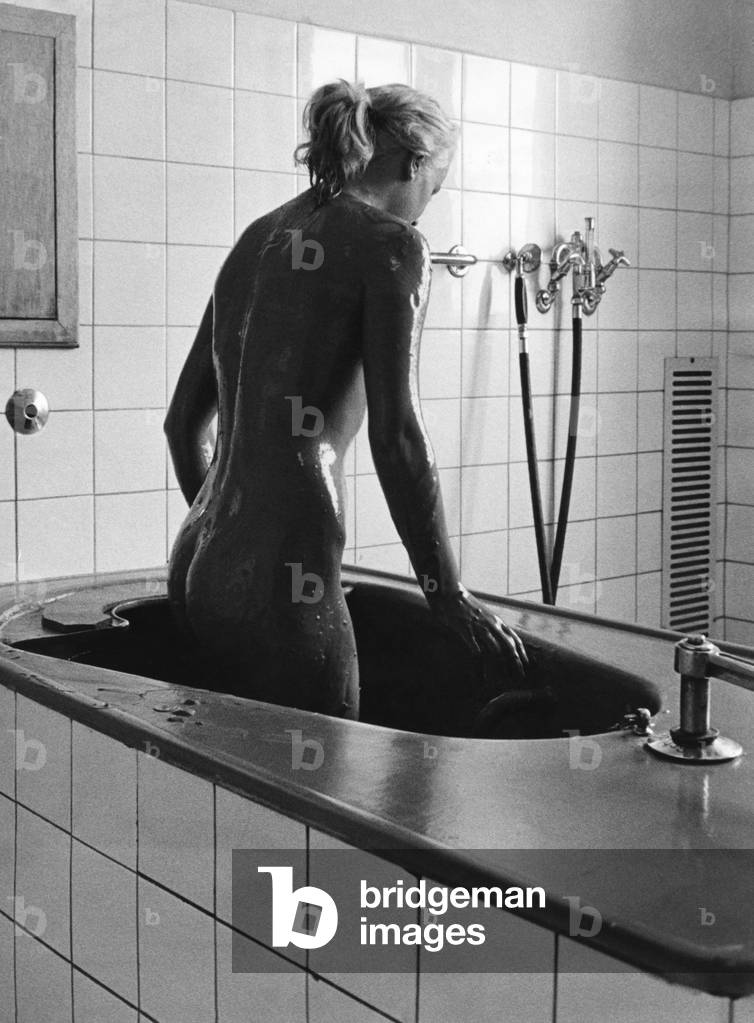 Woman getting out of the bathtub, 1970s (b/w photo)