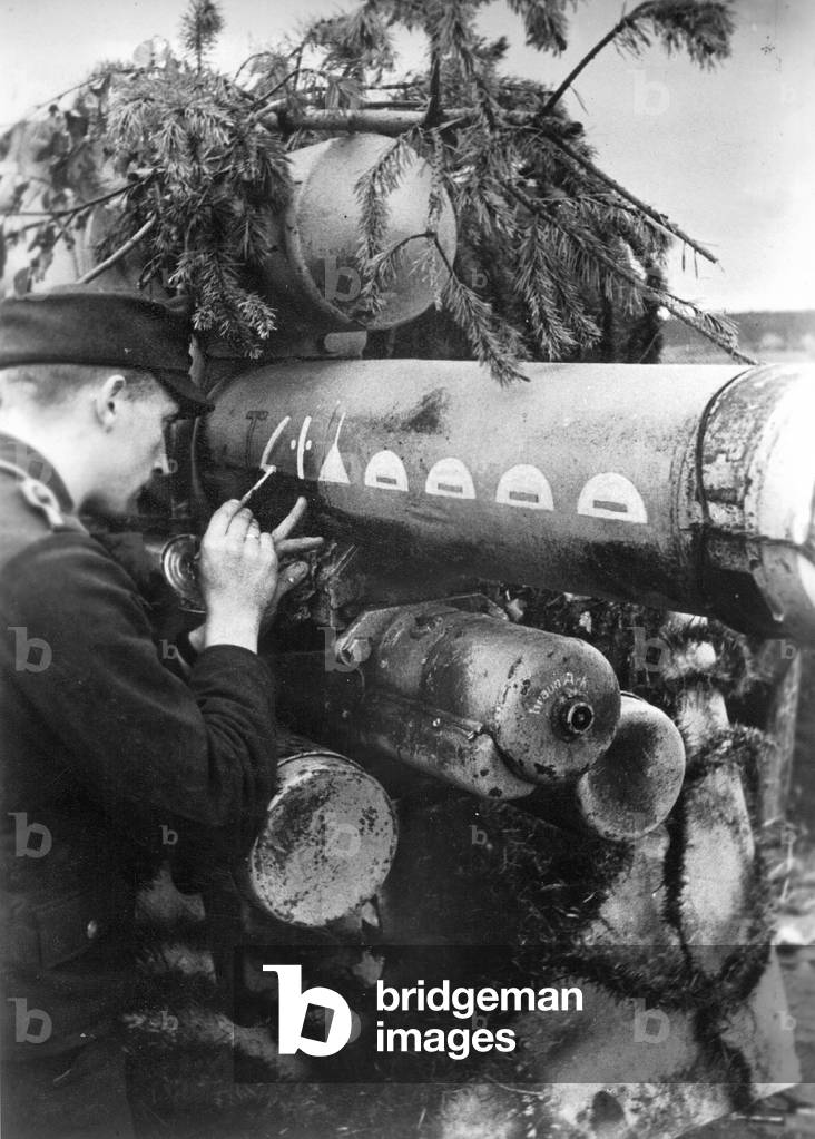 German soldier marks successful hits on a Flak gun, 1944 (b/w photo)