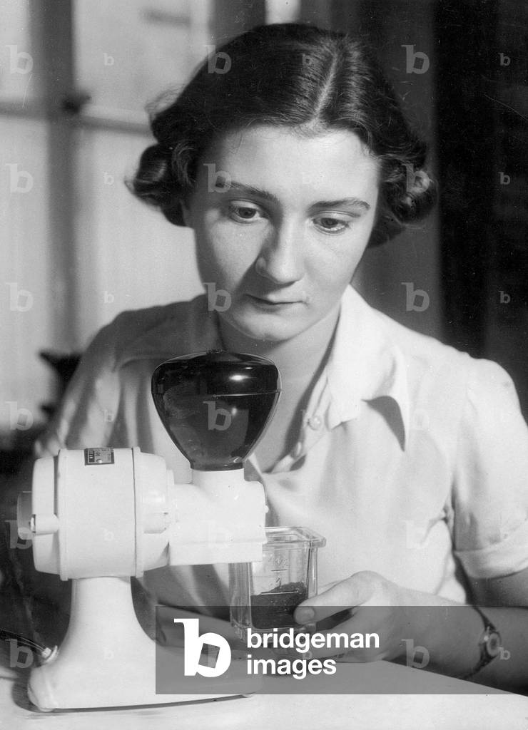 A housewife grinds coffee, 1938 (b/w photo)