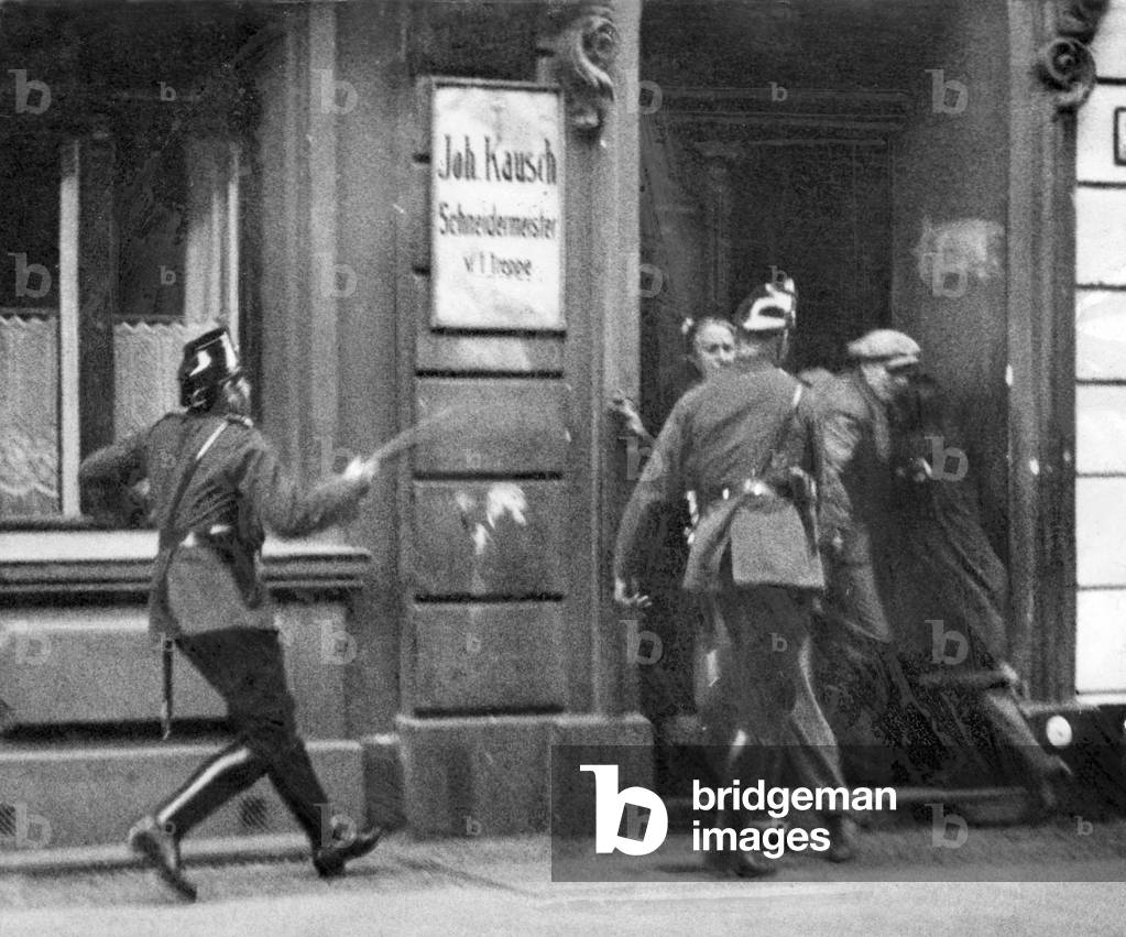 Policemen chase participants of a street fight, 1931