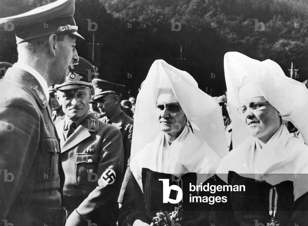 Gauleiter (District leader) Hoffmann awards the War Service Cross to nuns, 1943 (b/w photo)