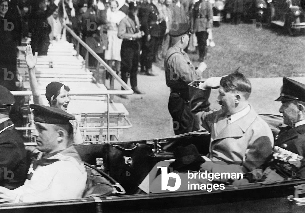 Adolf Hitler salutes from car (b/w photo)