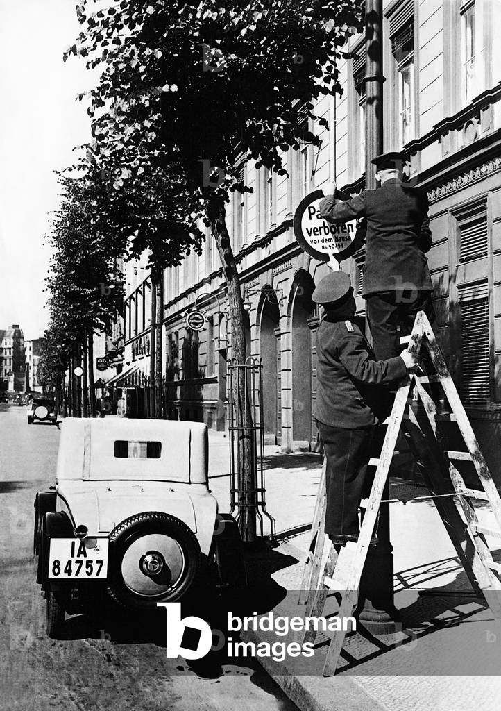 Firemen put up a no-parking sign, 1931 (b/w photo)