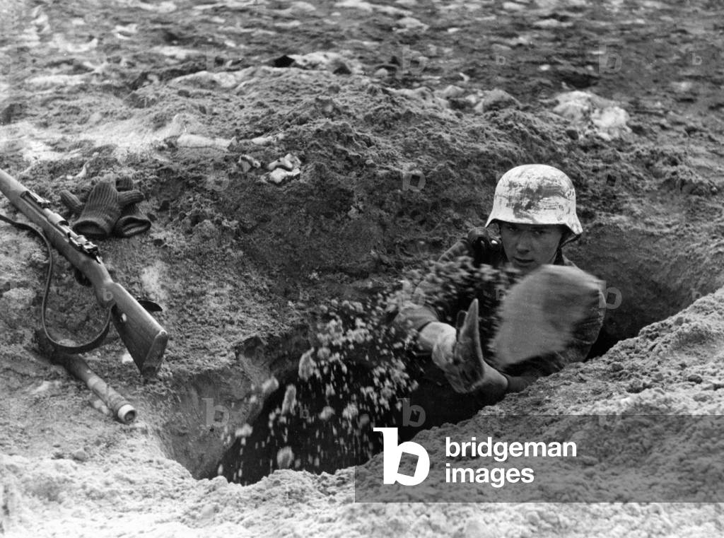 Recruit digging a foxhole, 1943 (b/w photo)